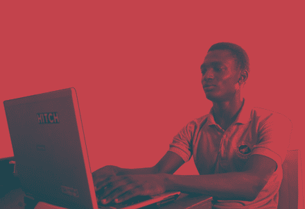 A young man focused on typing into a computer